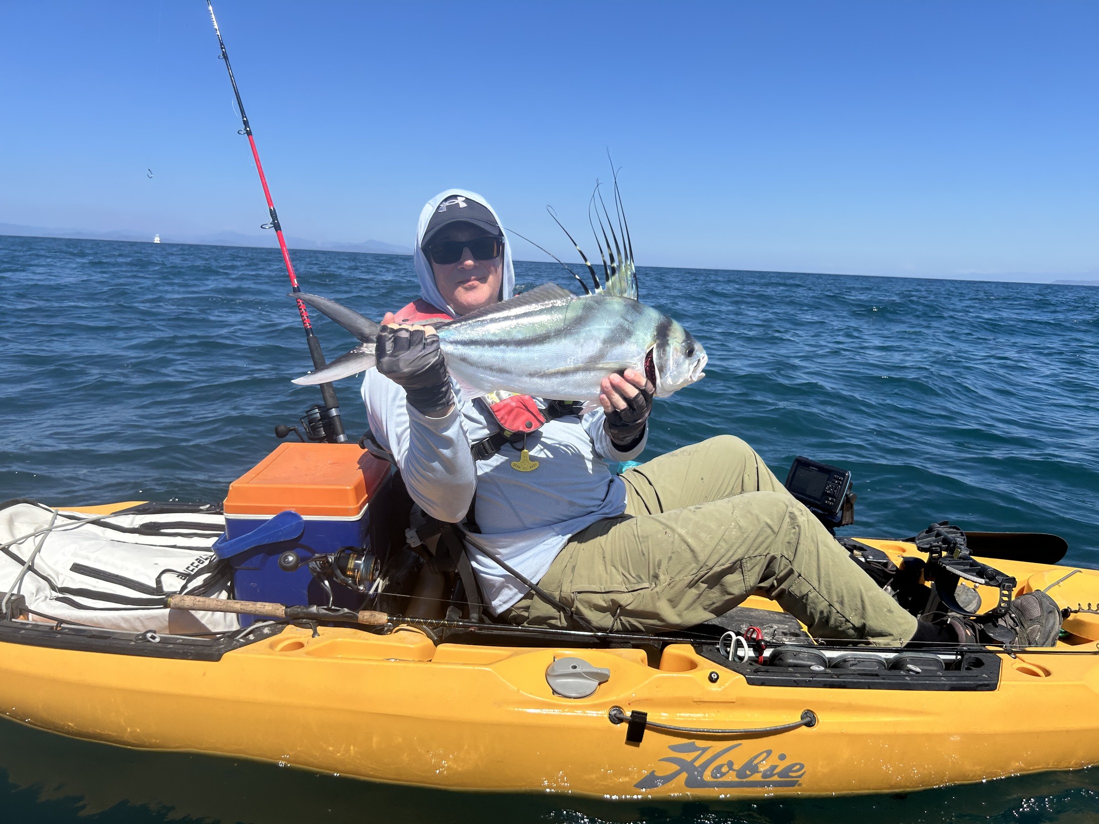 Kayak angler holding a roosterfish on Costa Rica's Pacific coast