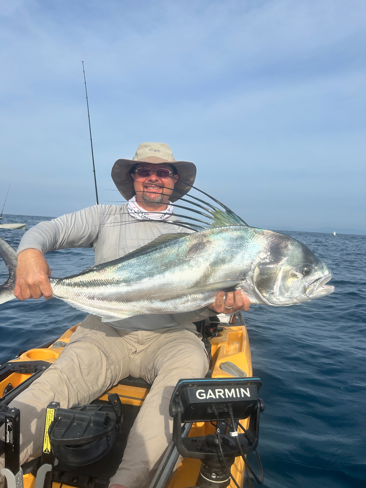 Ryan, the owner of Pacific Kayak Fishing, standing near the ocean with kayaks in the background, conveying a professional and adventurous spirit in Costa Rica.